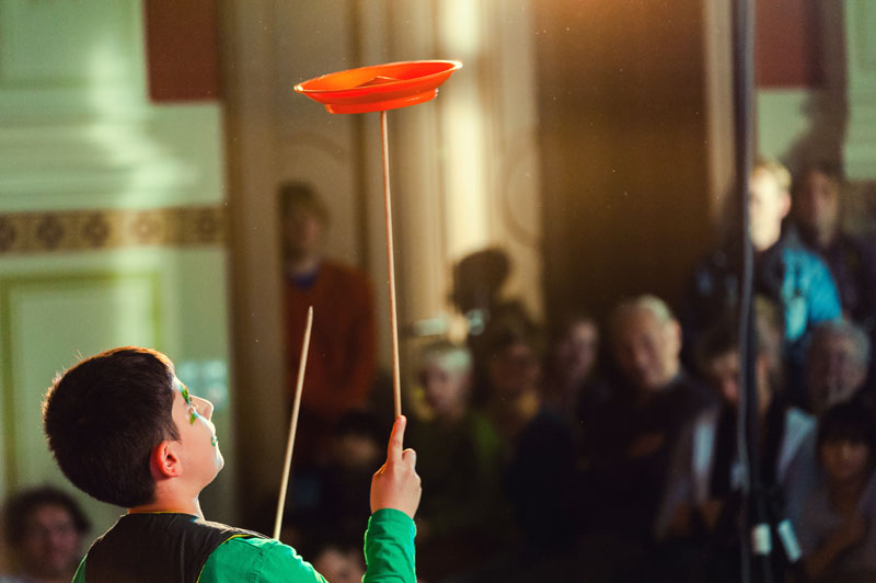 Junge vor Publikum beim Tellerdrehen